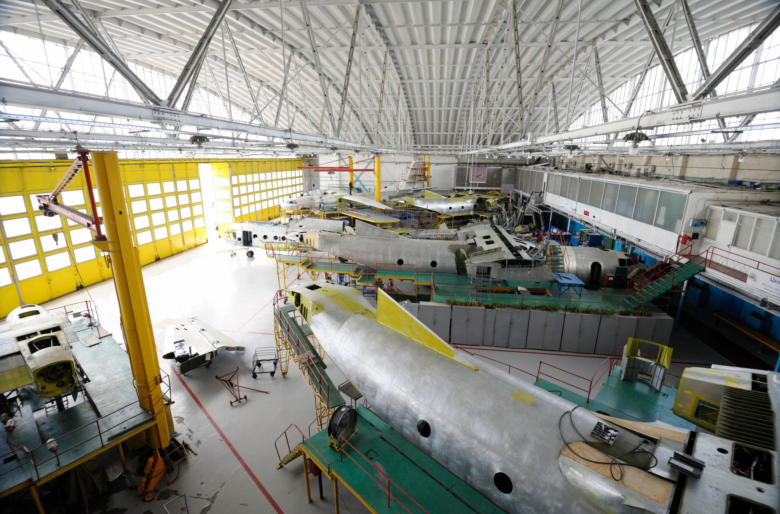 Maintenance hall with planes standing in aircraft fixtures for repair. The State Aircraft Repair Plant 410